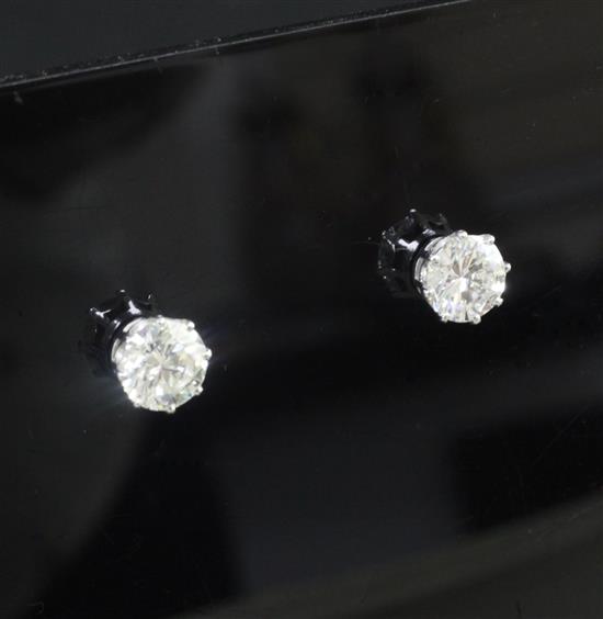 A pair of 18ct white gold and solitaire diamond ear studs,